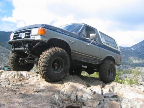 1989 Ford Bronco - This modified 1989 Ford Bronco tackles a challenging rocky trail with its large off-road tires.