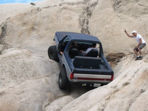 1989 Ford Bronco - 1989 Ford Bronco tackling a challenging off-road course on rocks.