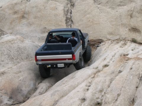 1989 Ford Bronco - A Ford Bronco tackles a challenging rocky path, demonstrating its off-road capabilities.