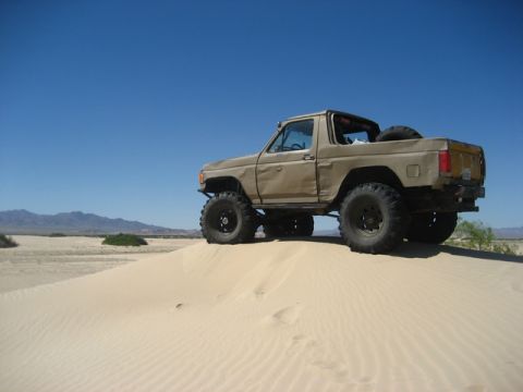 1989 Ford Bronco - Modified 1989 Ford Bronco parked on a sand dune in a desert.