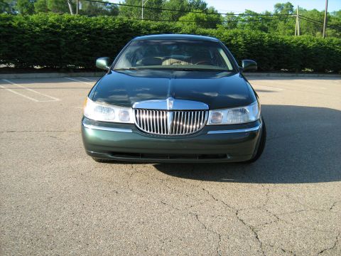 1988 Mercury Grand Marquis - This green sedan displays a prominent chrome grille and is parked outdoors.