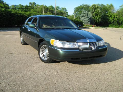 1988 Mercury Grand Marquis - Front view of a dark green sedan, likely a 2001 Lincoln Town Car, with a prominent chrome grille.