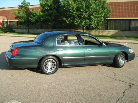 1988 Mercury Grand Marquis - This green sedan has a distinctive body style and chrome accents, indicating a model year around 2001.
