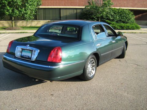 1988 Mercury Grand Marquis - This green sedan is shown from the rear 3/4 view. The license plate is visible and reads 'Cormoran'.