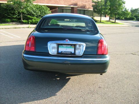 1988 Mercury Grand Marquis - Dark green Lincoln Town Car seen from the rear, parked in a lot.