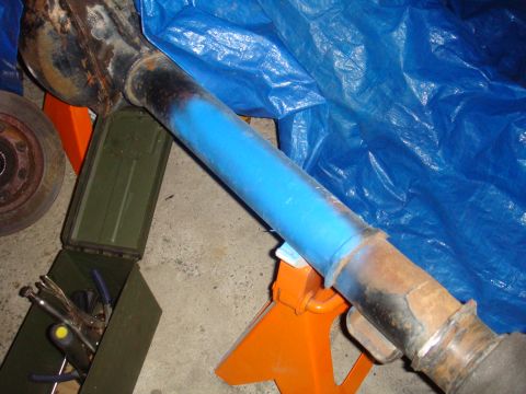 1992 Ford Bronco - Vehicle axle assembly painted blue, supported by jack stands in a garage setting.