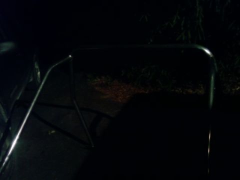 1995 Ford Bronco - A partial view of a vehicle's chrome trim is visible in the darkness.