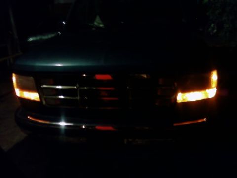 1995 Ford Bronco - Front view of a 1992 Ford Bronco with headlights and grille visible in the dark.