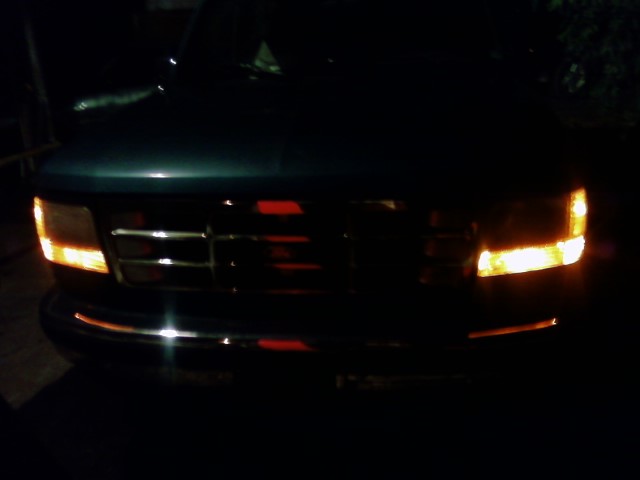 1992 Ford Bronco front grille and headlights illuminated at night