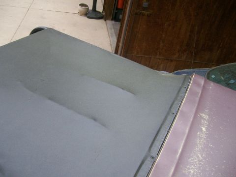 1993 Ford Bronco - Close-up of a gray primered hood or panel with a raised center bulge, resting alongside a pink-primered body panel with sanding scratches.…
