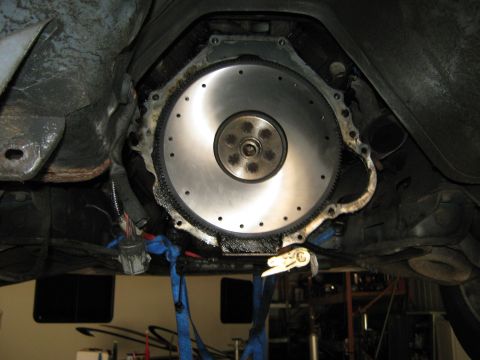 1985 Ford Mustang - Underneath view of a vehicle's flywheel and transmission bell housing, likely during maintenance.