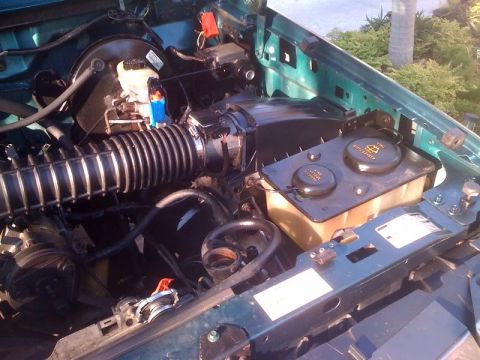 1996 Ford Bronco - The engine bay of a 1996 Ford Bronco, the air intake system and coolant reservoir.