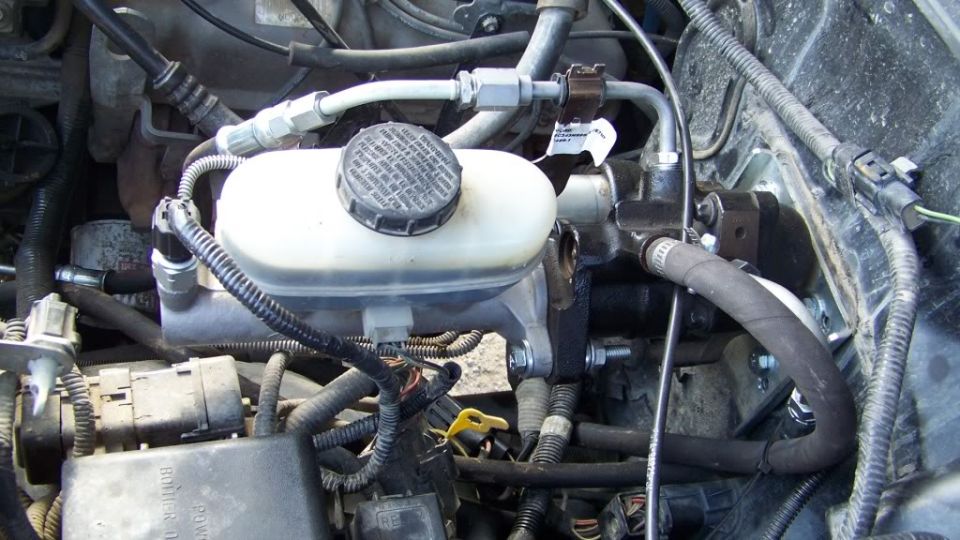 Close-up of a brake master cylinder with hoses and wiring