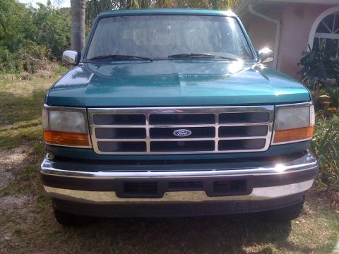 1996 Ford Bronco - Front view of a green 1996 Ford Bronco, its distinctive grille and headlights.