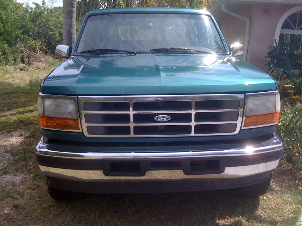 Green 1996 Ford Bronco front end with chrome grille and headlights