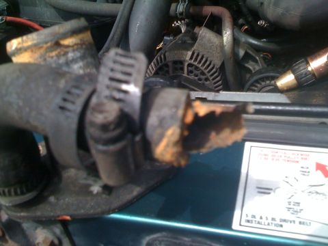 1996 Ford Bronco - Close-up of a corroded hose and engine components, with a diagram visible in the lower right corner.