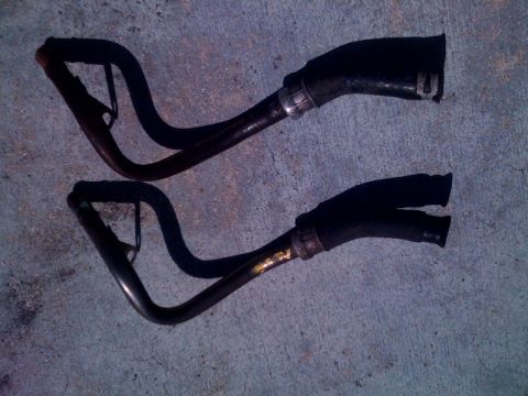 1996 Ford Bronco - Two automotive hoses are shown on a concrete surface, likely for replacement or repair.