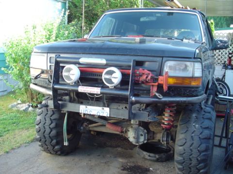 1993 Ford Bronco - This 1993 Ford Bronco features a custom bull bar, auxiliary lights, and large off-road tires, suggesting it's modified for terrain.