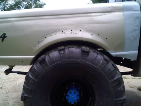 1997 Ford Ranger - This truck features oversized tires and shows signs of wear and tear around the rear wheel well.
