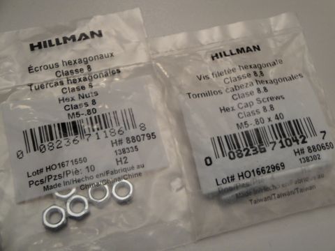1993 Ford Taurus - Packages of Hillman hex nuts and hex cap screws are shown, with visible barcodes and product details.