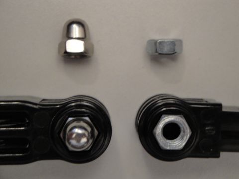 1993 Ford Taurus - Close-up view of a dome nut and a hex nut, alongside tools designed to grip them.