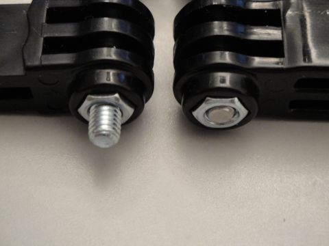 1993 Ford Taurus - Close-up of two camera mount parts, one with a screw and nut, the other with a nut.