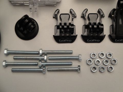 1993 Ford Taurus - Various GoPro mounting accessories and hardware are laid out on a white surface.