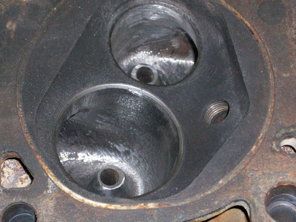 Close-up of an engine cylinder head with two large intake ports and smaller passages