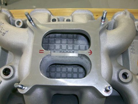 1973 Ford Ranchero - Close-up of an intake manifold, showing the carburetor mounting surface and internal passages with directional arrows.