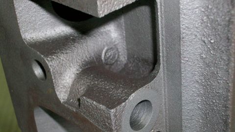 1973 Ford Ranchero - This is a close-up view of a cast iron engine part, showing its intricate internal structure and mounting points.