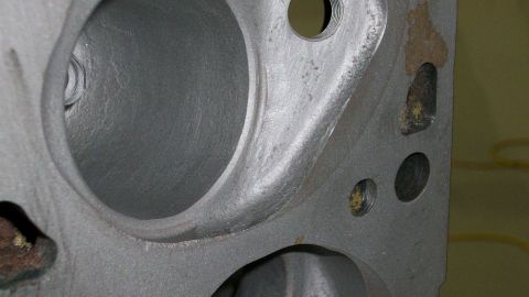 1973 Ford Ranchero - A close-up view of a gray metal engine cylinder head, showing internal casting details and bolt holes.