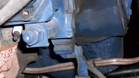 1973 Ford Ranchero - A close-up view of a blue engine block shows a spark plug and a large bolt securing a bracket.