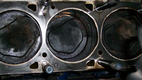 1973 Ford Ranchero - Close-up view of an engine's cylinder block and pistons, showing wear and carbon deposits.