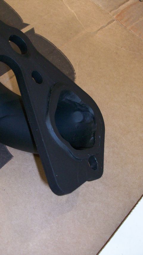 1973 Ford Ranchero - Close-up view of a black exhaust manifold part, likely for a vehicle engine.