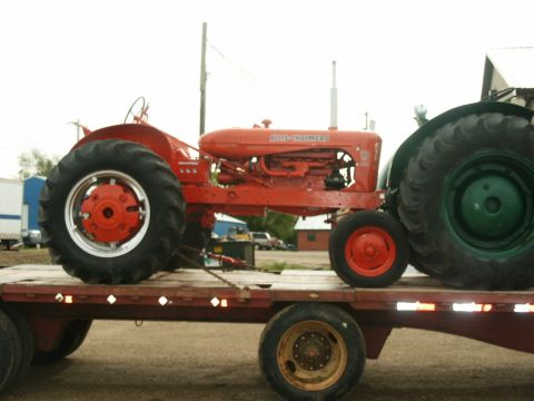 2000 Ford F-250 - An orange Allis-Chalmers tractor is transported on a flatbed trailer alongside another green tractor.
