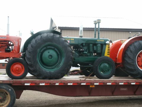2000 Ford F-250 - A green Oliver Super 99 tractor is seen on a flatbed trailer alongside other farm equipment.