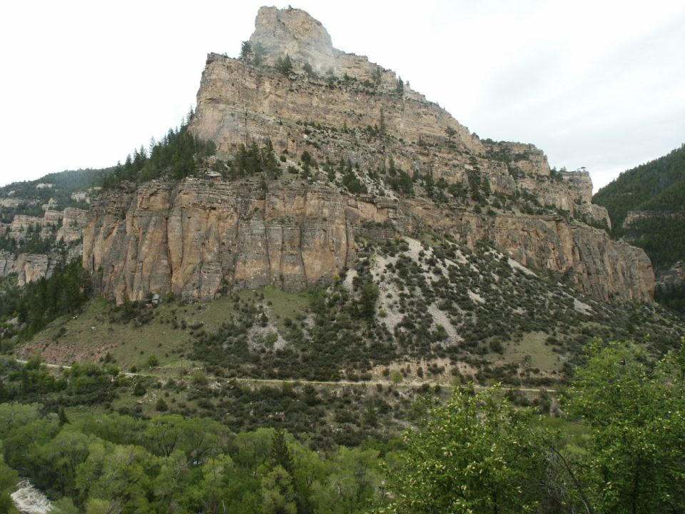 Mountain cliffs with a road winding through the vegetation below