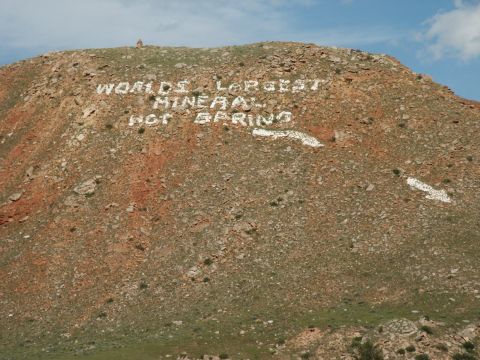 2000 Ford F-250 - White painted letters on a hillside declare it the "WORLD'S LARGEST MINERAL HOT SPRING" under a blue sky.