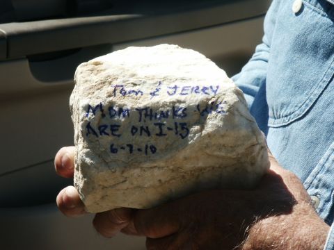 2000 Ford F-250 - A rock with handwritten messages and a date is held by a person, with part of a vehicle interior visible in the background.