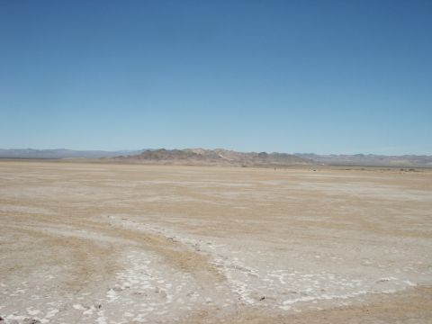 2000 Ford F-250 - Vast desert terrain stretches towards distant mountains under a bright blue sky.