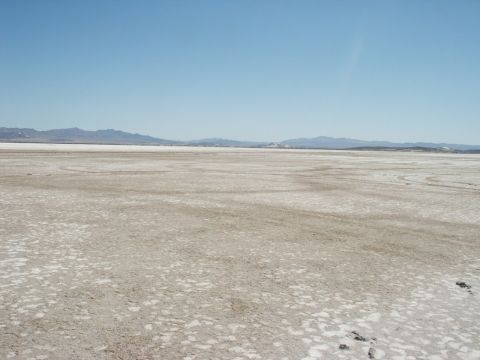 2000 Ford F-250 - Expansive dry lake bed stretches to the horizon, with mountains visible in the distance under a clear sky.