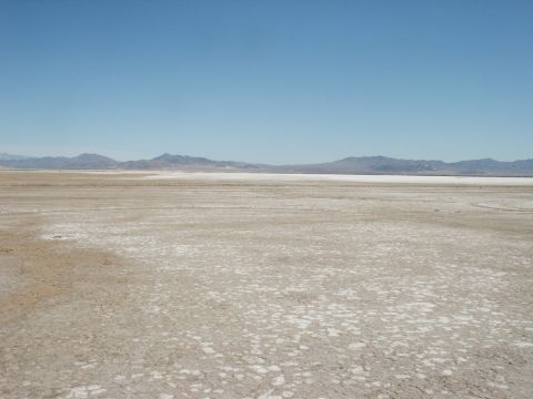 2000 Ford F-250 - Vast, arid landscape with a dry lake bed and distant mountains under a bright blue sky.