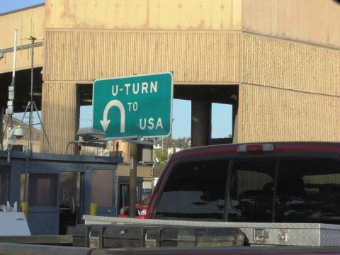 1986 Ford Bronco - A sign directs drivers to make a U-turn to return to the USA at a border crossing.