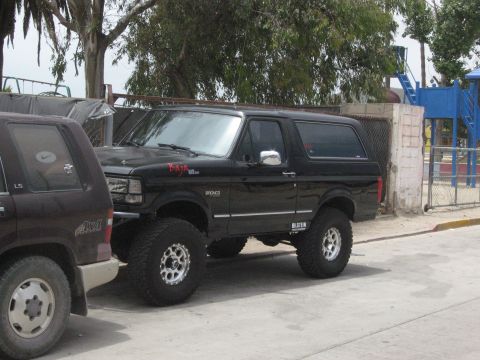 1986 Ford Bronco - This modified Ford Bronco features prominent Baja graphics and Bilstein suspension components, suggesting off-road capabilities.