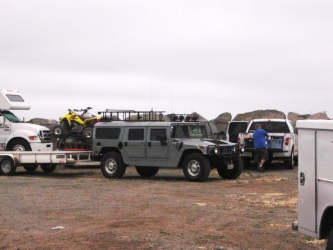 1986 Ford Bronco - Hummer H1 and ATV being transported on a trailer, with a pickup truck in the background.