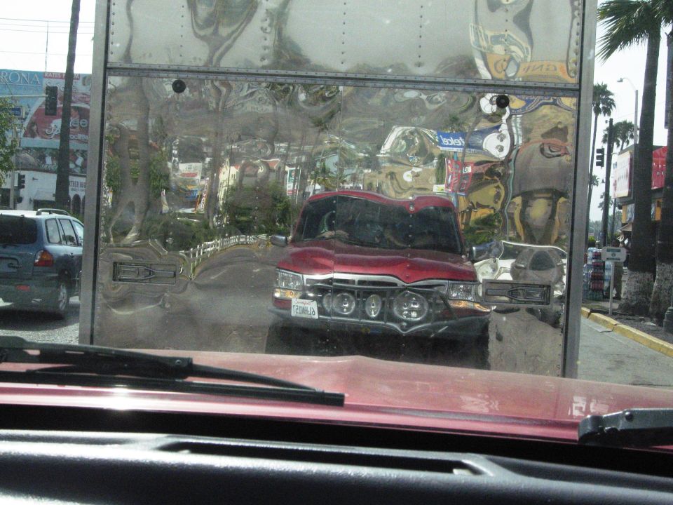 Red truck with chrome grille, four round headlights, and a license plate reading "T206JB"