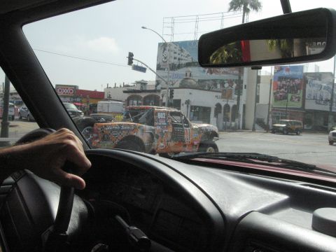 1986 Ford Bronco - A heavily modified off-road truck with racing decals is visible on a city street.