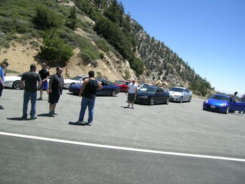1993 Ford Probe - A group of cars and people gathered at a scenic mountain viewpoint on a sunny day.