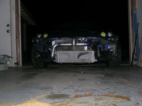 1995 Ford Probe - Front view of a car undergoing modifications, showing an exposed intercooler and turbo piping.