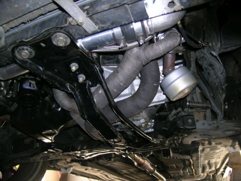 1995 Ford Probe - Custom turbo setup visible on the underside of a vehicle, exhaust heat wrap and intercooler piping.